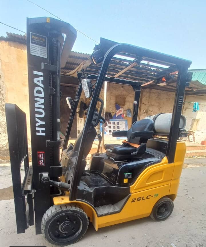 Brand new yellow Hyundai 25LC-9 forklift with 3-stage mast, side view